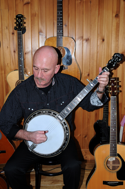 Fraser Nimmo playing banjo in his studio