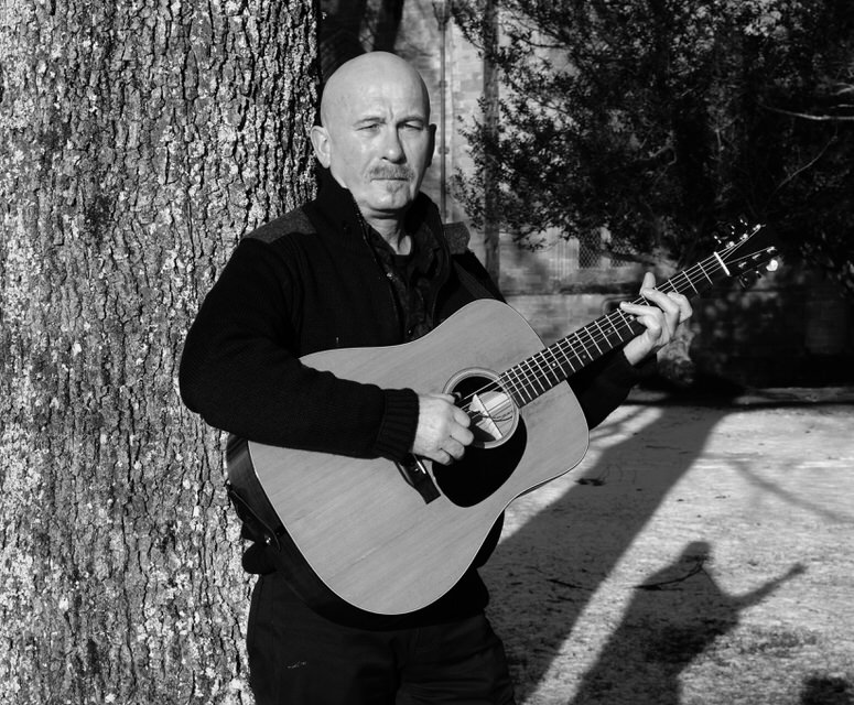 Fraser Nimmo plays acoustic guitar